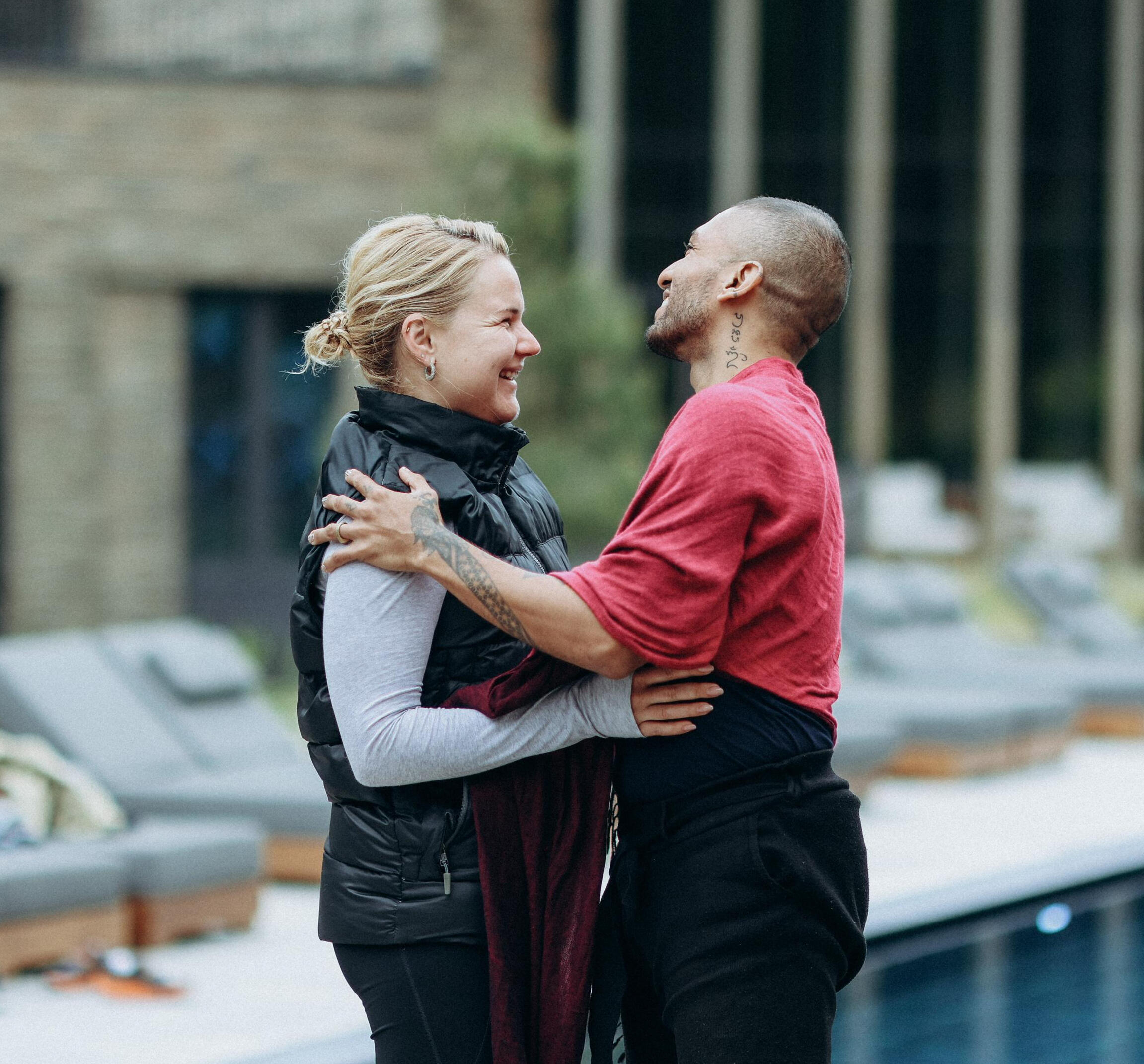 Transformational Coaching Journey – Free Lopez in Coaching session with a woman Free Lopez guiding a woman during a holistic coaching session beside a tranquil pool, as both are laughing together with enthusiastic eyes, reflecting human connection, joy, transformation and personal growth.